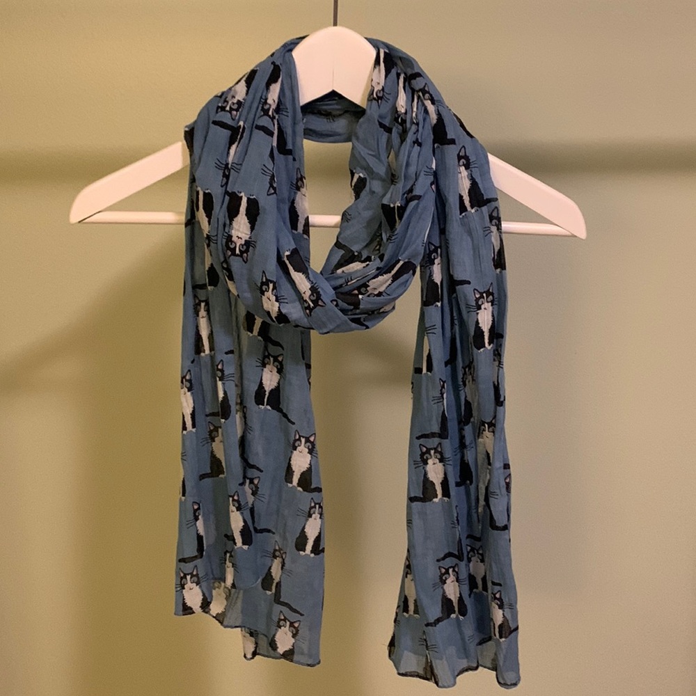 Blue scarf with black and white cat pattern.